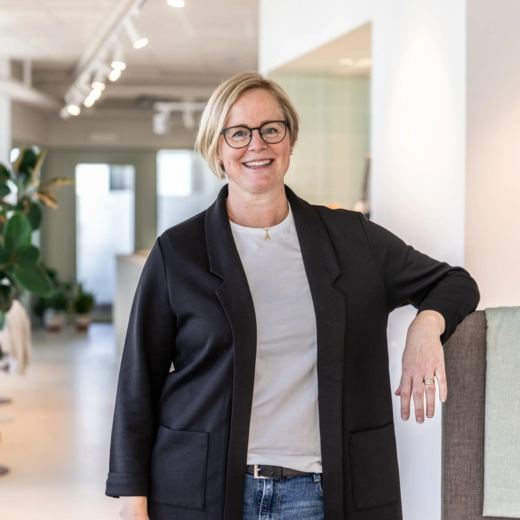Anki från Inspirea poserar framför kameran i deras kontorsmiljöer