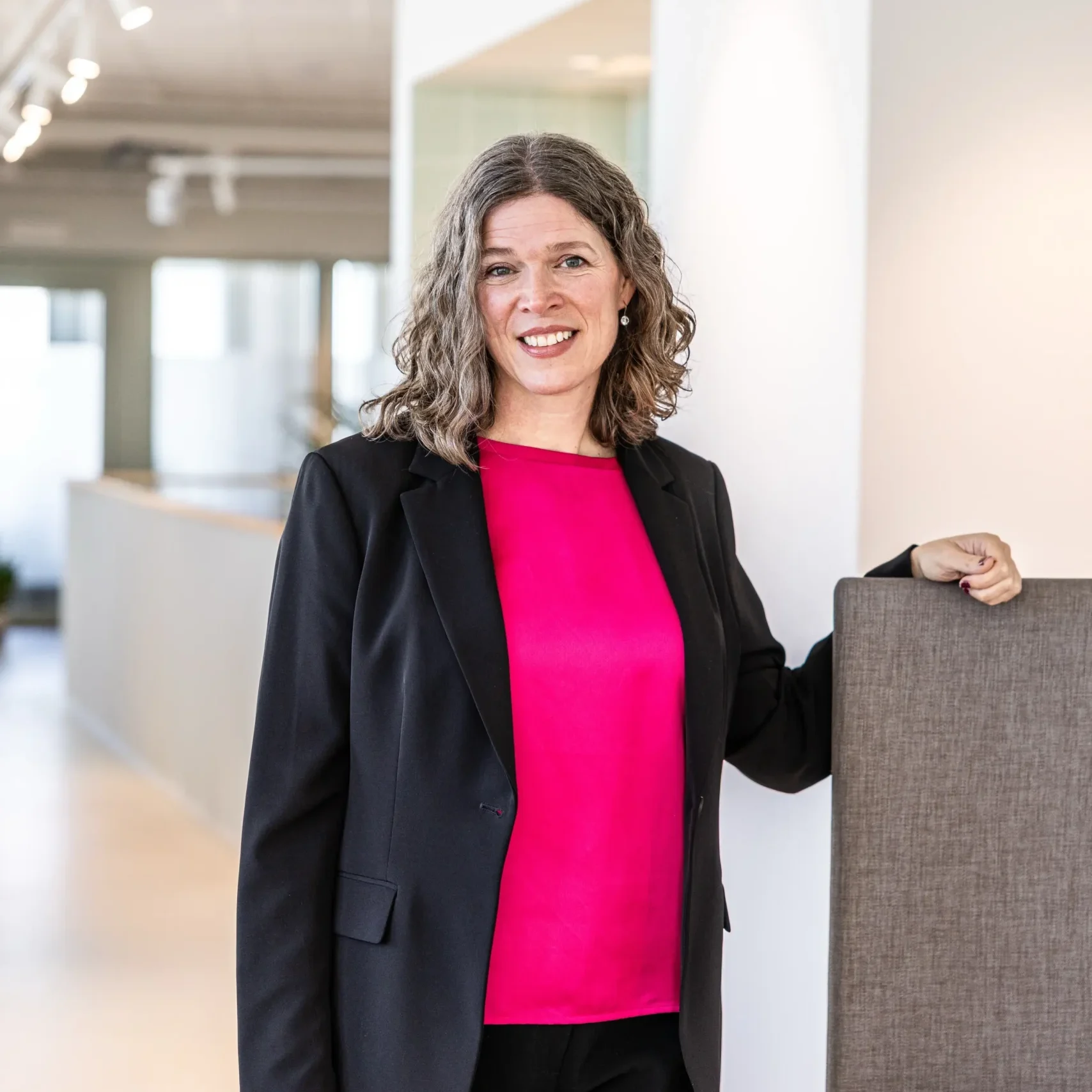 Malin från Inspirea poserar framför kameran i deras kontorsmiljöer