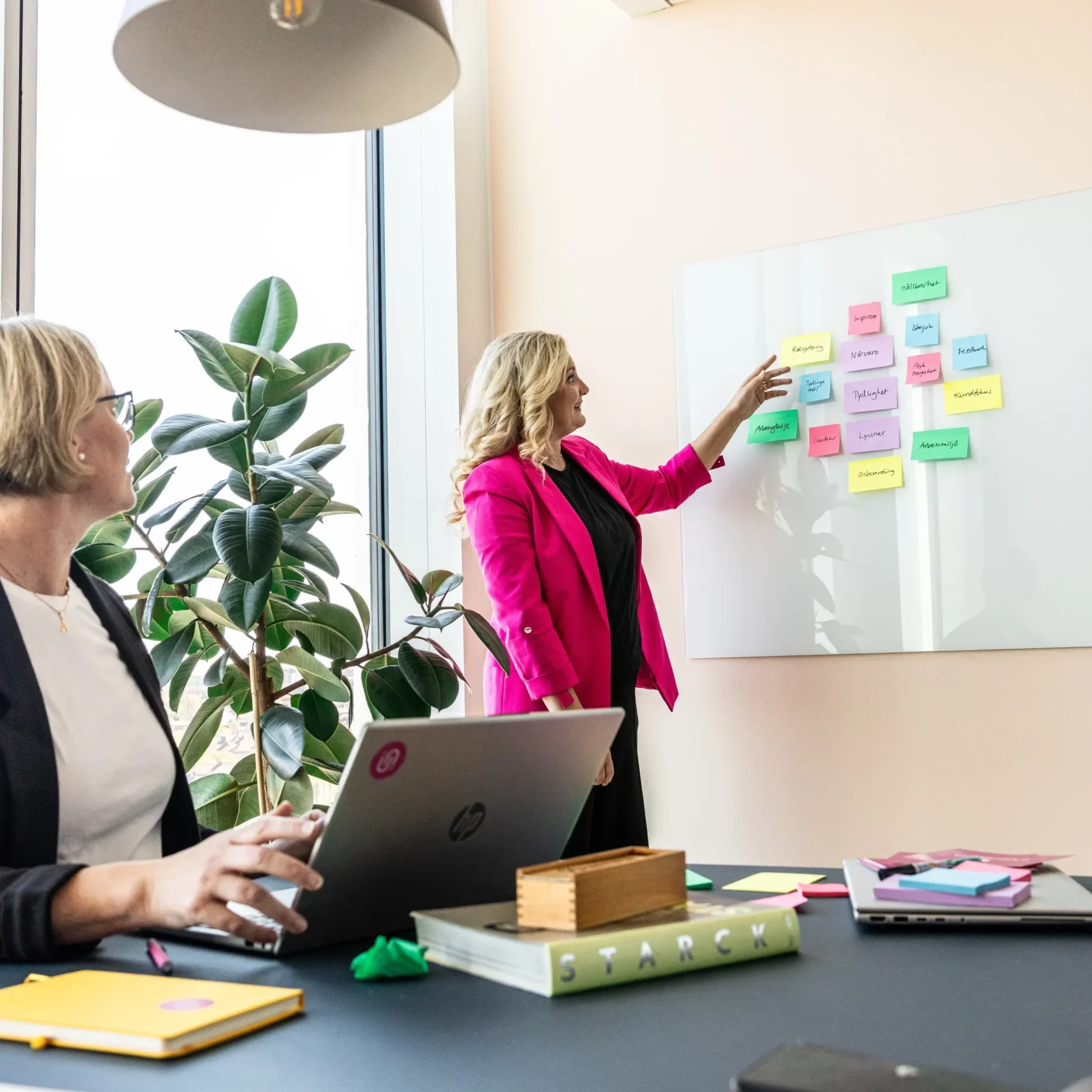 Jessica visar upp postit-lappar i olika färger med olika budskap för Anki