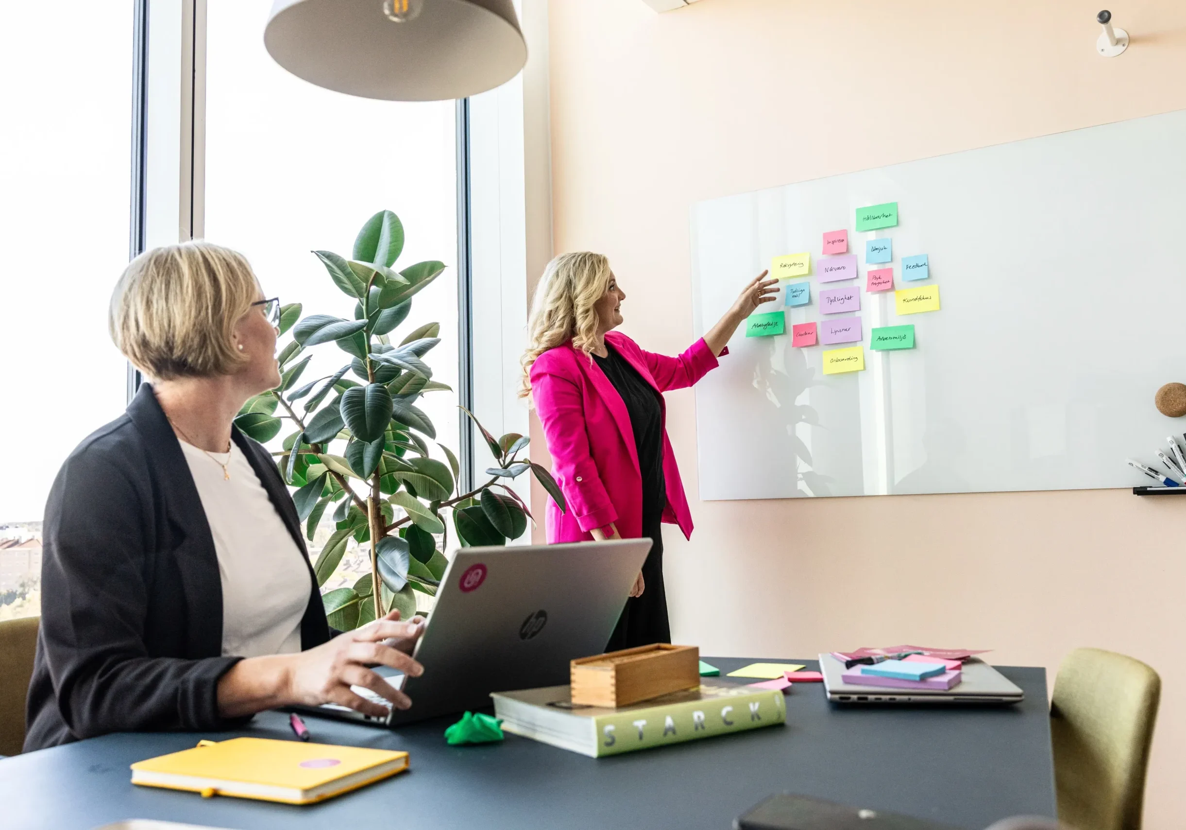 Jessica visar upp postit-lappar i olika färger med olika budskap för Anki